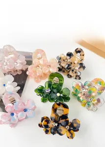 Gros plan de pinces à cheveux fleurs en acétate avec strass en divers coloris et motifs