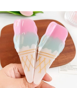 Close-up of ice cream cone shaped hair claws in pink, mint green and cream white colors