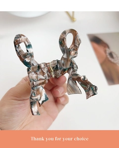 Detailed view of the marble pattern acetate butterfly hair claw with a gold metal spring