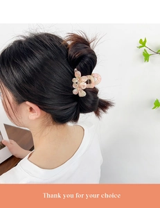 Gros plan d'une pince à cheveux fleur rose en acide acétique dans un chignon