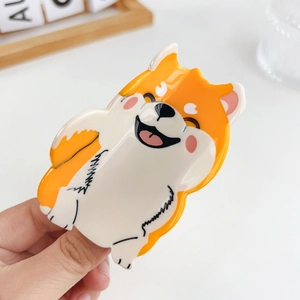Handheld cute orange and white Shiba Inu hair claw clip with a glossy acetate finish
