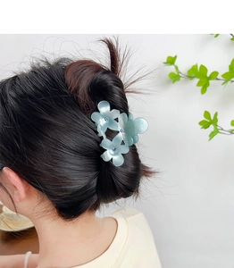 Détail de la pince à cheveux fleur bleue avec strass portée pour un style doux et élégant