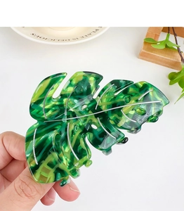 Macro shot of green Monstera leaf hair claw clip made of glossy acetate resin material