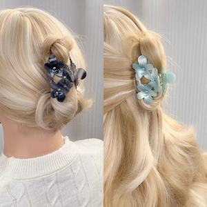 Pinces à cheveux en acétate avec fleurs grises et bleues et strass sur cheveux bouclés
