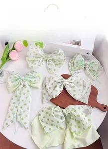 Detail of light green floral and polka dot ribbon hair bows with pearls on wooden tray