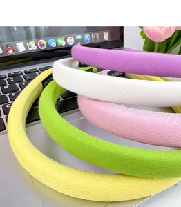 Detail of five assorted thick padded sponge headbands in soft pastel colors and mesh texture