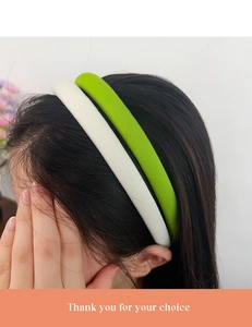 Detail view of stylish thick padded headbands in white and soft green worn on a model