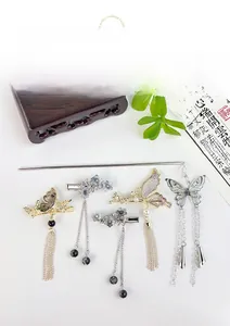 Détail de pinces à cheveux papillon de style chinois avec d'élégants glands en métal