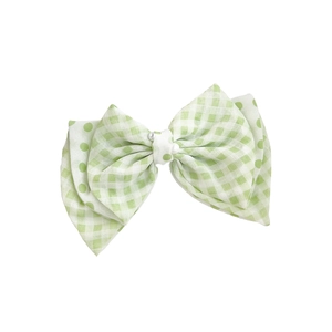 Chouchou noeud vert clair à carreaux avec pois et perles décoratives sur fond blanc