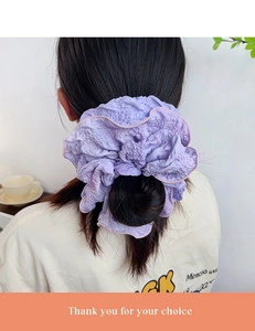 Detail of purple textured scrunchie showing fabric pleats and soft cloud-like ruffles