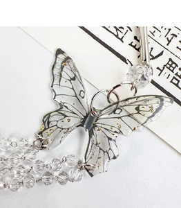 Gros plan sur la pince à cheveux papillon avec feuille d'or et pampilles en cristal