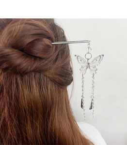 Détail d'un pic à cheveux papillon argenté élégant avec de longs glands perlés sur modèle