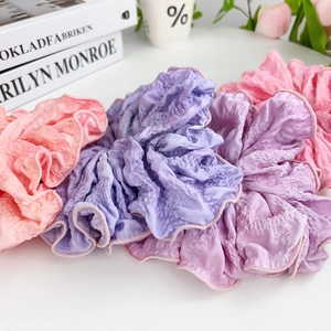 Elegant gradient fabric hair scrunchies in lavender and pink displayed on a desk