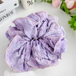 Elegant purple and pink gradient scrunchie with seersucker texture on white tabletop