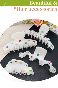Detail of pearlescent acetate hair claws with colorful rhinestone floral patterns