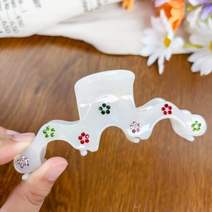 Iridescent acetate hair claw clip with colorful rhinestones and wavy edge design