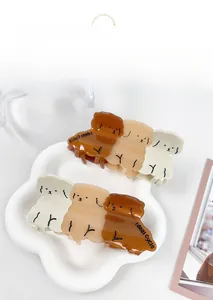Three gradient brown teddy dog hair claws on a decorative white floral tray detail