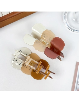 Close-up of wavy brown and beige acetate hair claws with a cute cartoon dog print