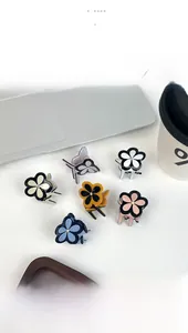 Flat lay of small clover acetate hair clips with crystal center in various colors