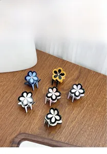 Set of six colorful floral hair claws with small diamond accents on dark wood