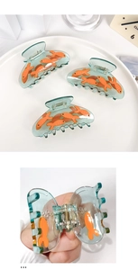 Détails de pinces à cheveux en acétate bleu clair ornées de motifs de carpes koï orange