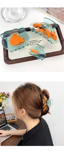 Vue détaillée des pinces à cheveux carpe koi en résine verte avec petits poissons oranges