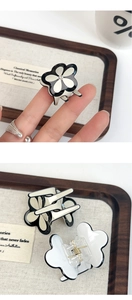 Close-up of four-leaf clover acetate hair claw with rhinestone and metal spring detail