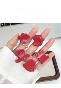 Detail of five mini red hair claws with gold France Handmade text on various shapes