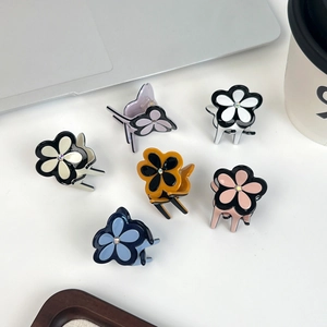 Set of six colorful four-leaf clover mini hair clips with rhinestones on a white desk