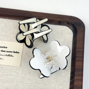 Elegant clover acetate hair claw set in cream and white with black trim and gold spring