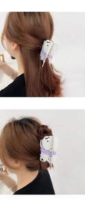 Detail showing a cute polar bear acetic acid hair claw clip on a half-up hairstyle