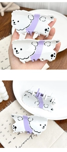 Detail of cute dog-shaped cream and purple acetate hair claw clip with spring teeth