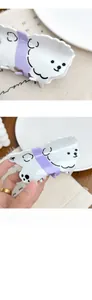 Close-up of cute white Bichon dog acetate hair claw clip with purple tie detail