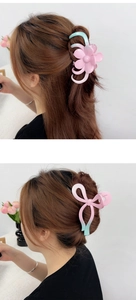 Detail of pink and green gradient hair claws in flower and bow shapes on hair