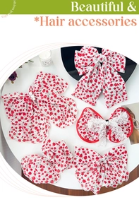 Detailed set of floral hair scrunchies and bow clips with pearls on a white table