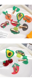 Detail of colorful acrylic vegetable hair clips showing durable gold metal duckbill clips