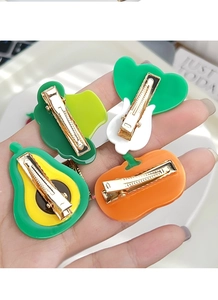 Detail showing back of fruit and vegetable hair clips with golden metal duckbill clips