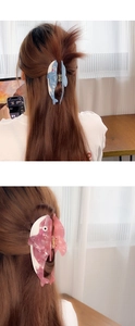 Detail of dolphin hair claw clips in blue and pink marble acetate for long hair styling
