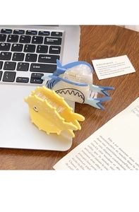 Detail view of cartoon shark and pufferfish hair claws next to a laptop on a wooden desk