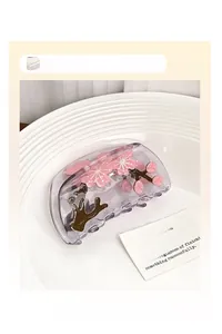 Detailansicht der lila Haarklammer mit rosa Pflaumenblütenmuster auf einem weißen Keramikteller