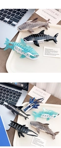 Shark-shaped hair claw clips with white dots in a stylish tray on a desk