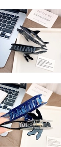 Macro detail of whale and shark hair claws in glossy black and translucent blue acetate