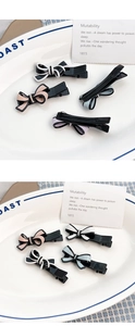 Détail de quatre barrettes à cheveux nuds en acétate coloré dans un plat blanc