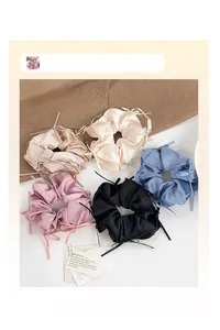 Vue détaillée du lot de 5 chouchous en satin avec de délicats nœuds en ruban aux tons pastel
