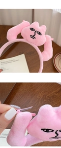 Vue détaillée du serre-tête lapin en peluche rose avec pinces latérales sur un bureau