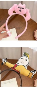 Gros plan de serre-têtes en peluche rose et imprimés avec expressions amusantes sur bois
