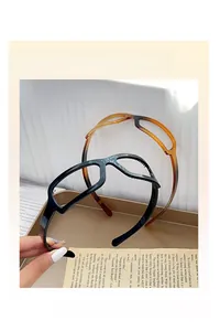 Detailed view of creative eyewear-shaped hairbands in glossy black and amber tortoiseshell
