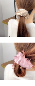 Détail de chouchous en satin avec rubans en champagne et rose, finition brillante