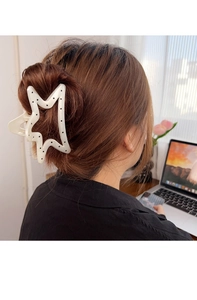 Pince à cheveux étoile à pois tenant un chignon haut dans un bureau cosy