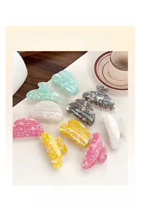 Close-up of pearlized wave pattern hair claw clips in colorful pastel finishes